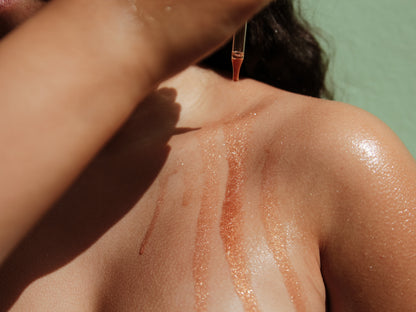 Applying Aura Shimmering Dry Body Oil on glowing skin, featuring a hint of shimmer and hydration.